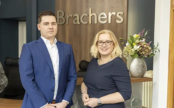 corporate solicitor Cameron gaston-penny and Corporate Partner Claire Williams standing in Brachers LLP reception