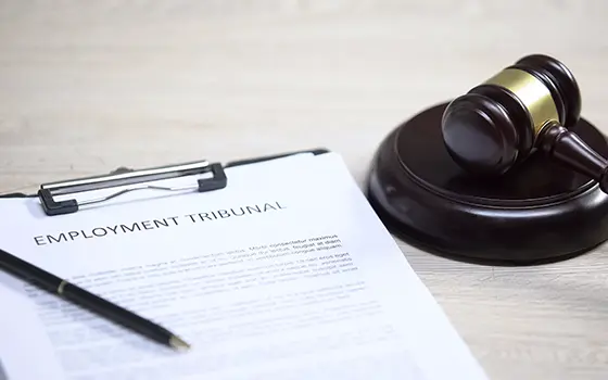 printed employment tribunal notes with a pen placed on top next to a gavel