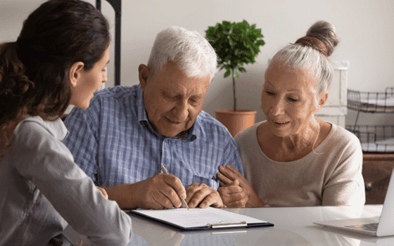 A lawyer overseeing an elderly couple signing documents