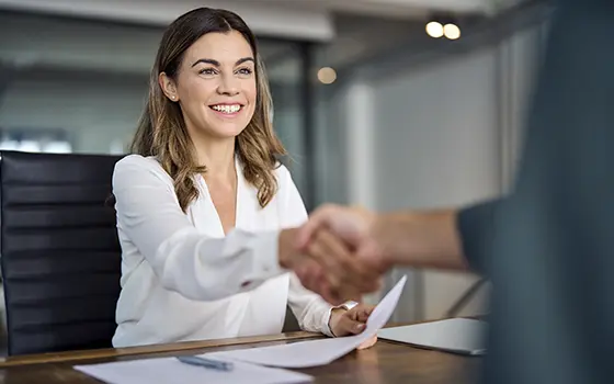 an office worker shaking hands with a colleague in a meeting room