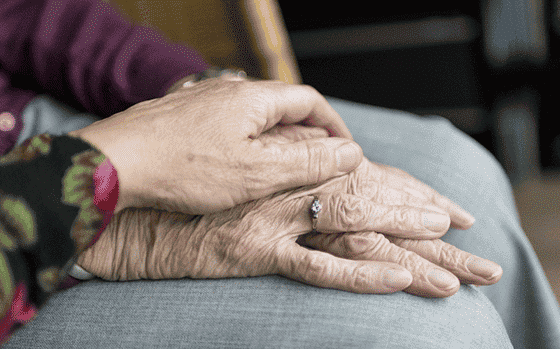 A hand on top of an elderly person's hand