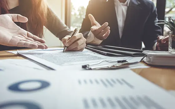 a man and a women discussing and signing business contracts