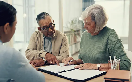 a man a women signing a legal document with their solicitor